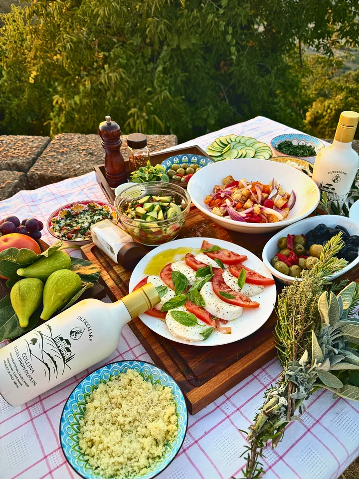 An Italian spread of tomatoes, mozzarella, olives and olive oil