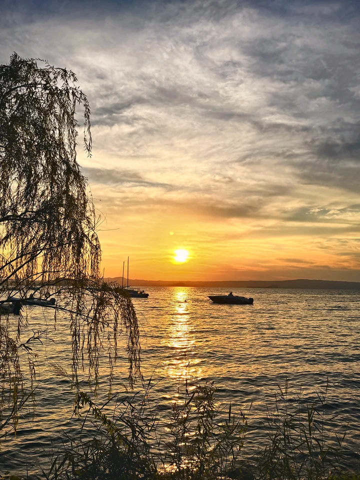 Sunset over an Italian lake with boats on the water