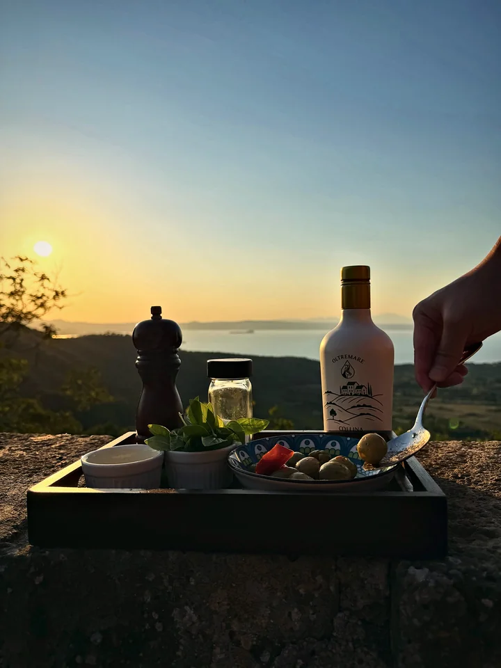 Olives, peppers and Oltremare olive oil on a terrace at sunset
